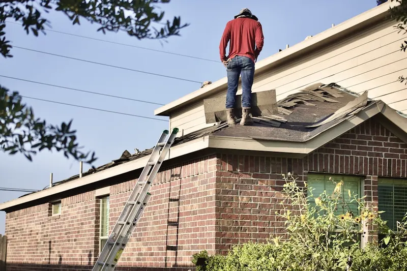 Professional roofer working on a residential roof in Rudeville